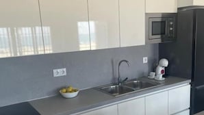 A modern kitchen with a stainless steel sink, a microwave, and a dishwasher. - Córdoba 8 by 7Escalones (Rota)