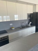 Una cocina moderna con un lavamanos de acero inoxidable, un microondas y un lavavajillas.