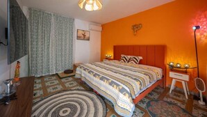 Une chambre à coucher comprenant un lit, un bureau, une chaise, une lampe et un élément décoratif mural.