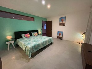 A bedroom with a bed, nightstands, a green wall, and two posters. - Suite Estrella de Turquia (Merida)