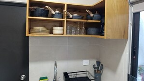 A kitchen with a wooden shelf holding cookware, a sink with a faucet, and a dish rack. - Loft moderno norte | Ideal parejas/trabajo (Merida)