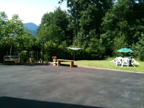 An outdoor area with a bench, a table with chairs, and a potted plant. - Gite de la Bruche in Schwartzbach (Russ)