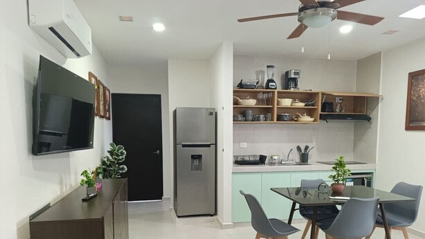Una cocina moderna con refrigerador, microondas y estantes de madera.