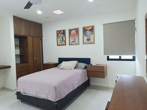 Une chambre à coucher comprenant un lit, des tables de chevet, une armoire et des œuvres d’art murales.