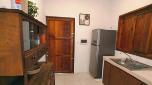 Eine Küche mit Holdekor-Schränken, einem Kühlschrank und einem Spülbecken.