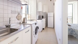 Una cocina compacta con lavadora, microondas y refrigerador.