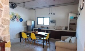 A compact kitchen with a dining table, chairs, a microwave, and a window. - Depto. cómodo en Progreso/ 1 Recamara/3 personas. (Progreso)