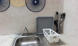 A kitchen with a sink, a white plastic basket, and a gray tray. - Disfruta Chicxulub/2 Recamaras/4 personas (Chicxulub)