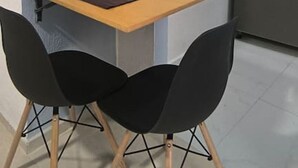A small kitchen with a table and two chairs, a refrigerator, and a flower vase on the table. - Loft acogedor y funcional Facturamos (Merida)