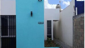 A building with a blue facade, a visible address '1219 15', and a small window with a metal gate. - Loft acogedor y funcional Facturamos (Merida)