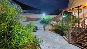 Un sendero que lleva a un edificio con una zona techada y una escalera.