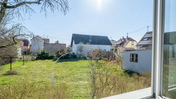 Un quartiere residenziale con case, un giardino erboso e cielo sereno.