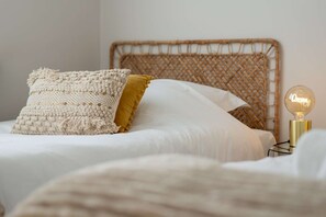 A bed with a woven headboard, a macrame pillow, a mustard-colored pillow, and a bedside lamp. - La Maison Royale - Haguenau Garden - 9 people (Haguenau)