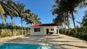 A house with a swimming pool, surrounded by palm trees and a clear sky. - Casa de playa estilo California en Telchac puerto (Telchac Puerto)