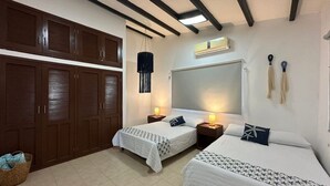 A hotel room with two beds, a wardrobe, a mirror, and a hanging light fixture. - Casa de playa estilo California en Telchac puerto (Telchac Puerto)