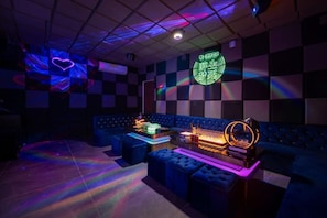 A room with a checkered wall, a neon sign, and a projection of a heart.