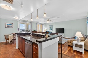 A spacious kitchen with a central island, pendant lighting, and a ceiling fan. - New! Oceanfront Penthouse/ 2 Decks/ Pool/Beach/Gym (Virginia Beach)