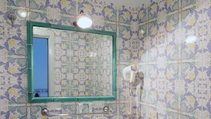 Een badkamer met een wastafel, spiegel en decoratieve tegels.