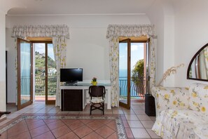 A room with a TV, a small table, a sofa, and a balcony with curtains. - Holidays Fico d Lndia (Furore)