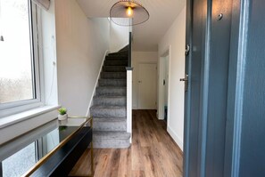 Eine Treppe mit modernem Design, einer Glastrennwand und einem Holzboden.