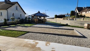 A courtyard with a gazebo, a small pond, and a stone pathway. - Holiday Home 'Gîte Rural Le Vendangeoir' with Private Garden and Wi-Fi (Colombé-la-Fosse)