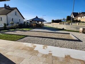 Ein Innenhof mit einem Pavillon, einem Teich und einem Kiesweg.