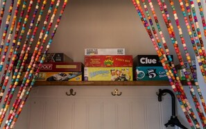 A shelf with various board games and a can opener.