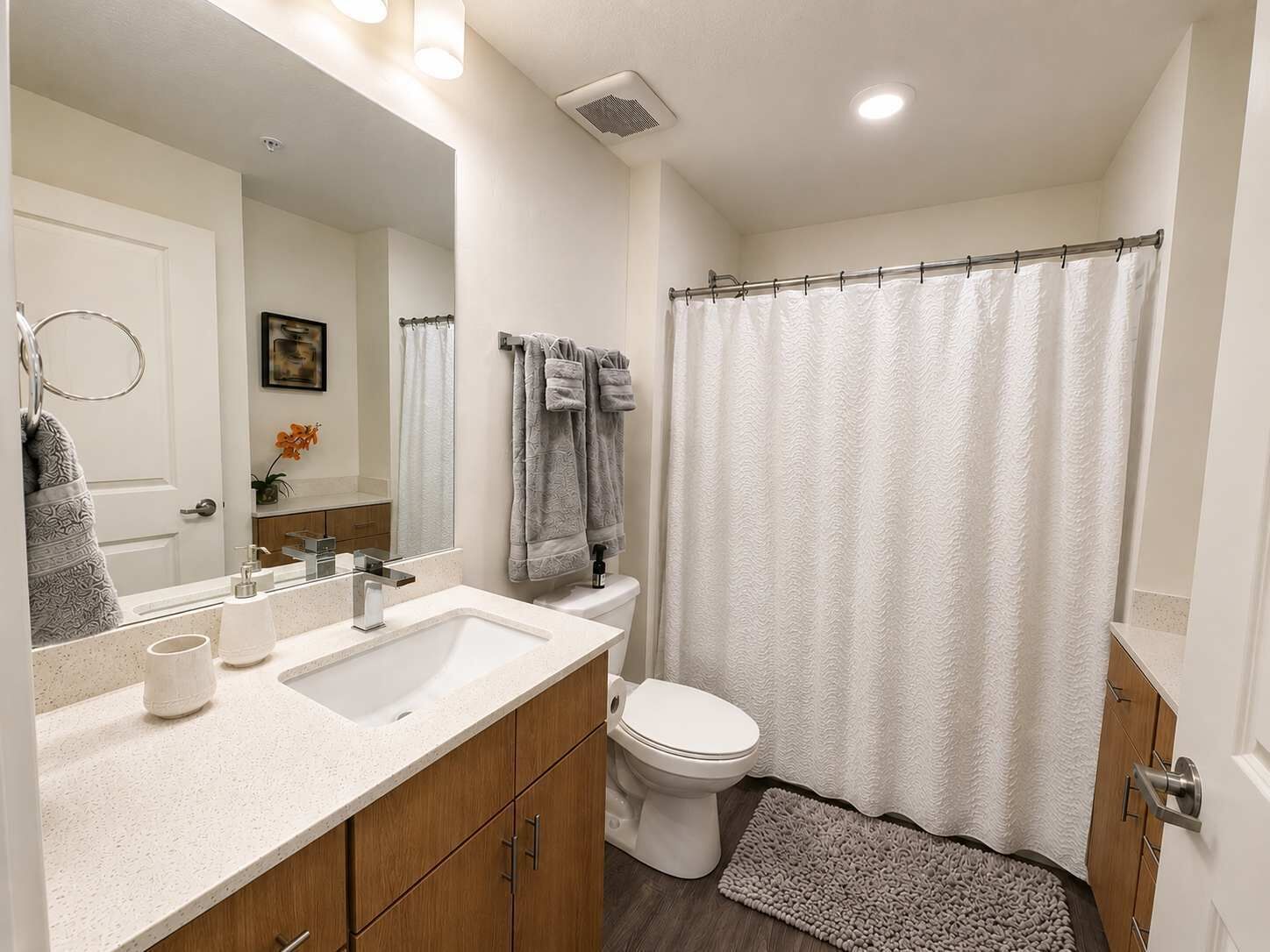 A bathroom with a sink, toilet, and shower curtain.