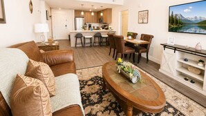 Una sala de estar moderna con sofá, mesa de centro y zona de comedor.