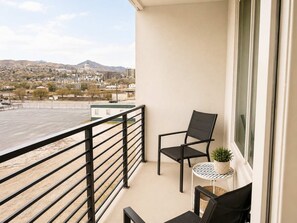 Ein Balkon mit Blick auf eine Stadtlandschaft, darunter ein Berg und ein gebäudegleiches Kapitol.