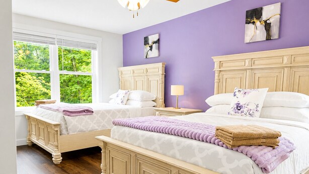 A bedroom with two beds, a window with a view of greenery, and a purple wall. - The South Harmony House, Luxury Escape, HotTub, 5,000sqft, Gameroom (Lake Harmony)