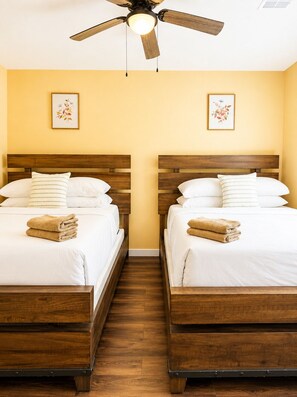 A hotel room with two wooden beds, a ceiling fan, and artwork on the walls. - The South Harmony House, Luxury Escape, HotTub, 5,000sqft, Gameroom (Lake Harmony)