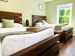 A hotel room with two beds, a window with a view of greenery, and a bedside table with a lamp. - The South Harmony House, Luxury Escape, HotTub, 5,000sqft, Gameroom (Lake Harmony)