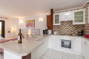 A modern kitchen with white cabinetry, a microwave, a coffee maker, and a toaster. - San Marino Studio 8 (Los Cristianos)