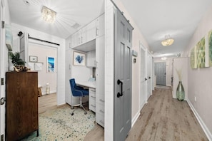 A hallway with a desk, chair, and a wooden cabinet. - Beach Resort 501 (Miramar Beach)