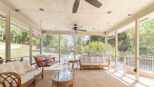 A covered patio with wicker furniture, a glass table, and a ceiling fan. - The Park House I Family Retreat Near Fort Benning & Auburn (Columbus)