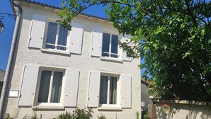 Een gebouw met twee verdiepingen, witte buitenmuren en luiken, een duidelijke deur en een klein bordje met de tekst 'PRIVÉ', wat aangeeft dat het privé-eigendom is.