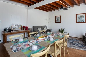 Un comedor con una mesa de madera dispuesta para seis personas, rodeada de sillas de madera.