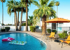 A swimming pool with palm trees, lounge chairs, and a lifeguard sign. - Stylish Tempe Stay ~ Swimming Pool, King Bed! (Tempe)