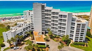 Un hotel de gran altura con varios balcones, un jardín en la azotea y vistas a la playa.