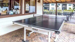 An outdoor ping pong table with a wooden ceiling and brick flooring. - Shorewalk 2BR/2BA Condo Minutes from Beach & IMG (Bradenton)