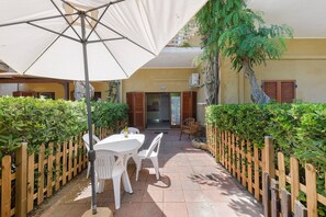 An outdoor patio with a table and chairs, a wooden fence, and a large umbrella. - Apartment 'Stella Di Mare Beach' with Sea View, Private Terrace and Air Conditioning (Naregno)