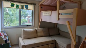 A child's bunk bed with a 'Tree House' label, a cushioned bench, a window with a view of greenery, and an air conditioning unit. - Stylish and Comfortable Home in Preston (Preston)