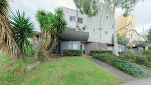 A residential building with a front yard, a pathway, and a small garden area. - Stylish and Comfortable Home in Preston (Preston)