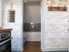 Una cocina con protector contra salpicaduras de madera, un lavamanos y una encimera. Hay un tablón de notas de la cocina en la pared y un letrero que anuncia un restaurante de cangrejo.
