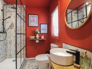 A bathroom with a shower, toilet, sink, and a mirror. - The Dinky Dairy (Oswestry)