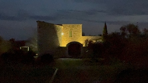 Ein Steinhaus mit einem zentralen Bogen, umgeben von Pflanzen.