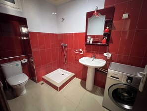 Chuveiro, toalhas de banho, sabonete, papel higiênico