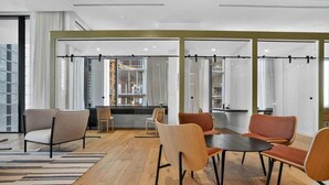 A modern interior with a wooden floor, a central table with chairs, and large windows with curtains. - The Crosby Miami Worldcenter (Miami)