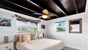 A bedroom with a bed, nightstands, a ceiling fan, and two windows with blinds. - La Pirata: Hgtv-Remodeled 3BR/2BA Canal Home w/ Pool (Marathon)